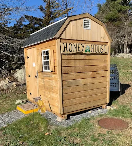 The Honey House, a small wooden shed with a "Honey House" sign